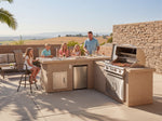 Cal Flame Carmel Q L-shaped BBQ island outdoor kitchen with family entertaining on a patio