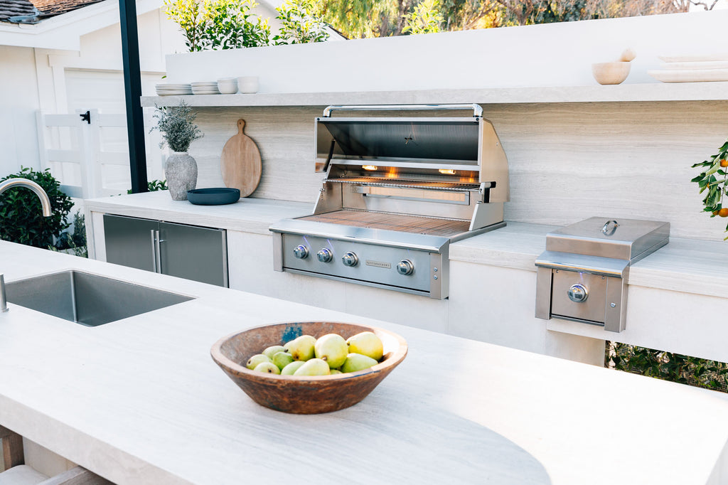 Summerset Alturi built-in gas grill installed in luxury outdoor kitchen island with side burner