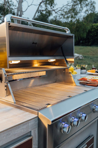 Summerset Alturi built-in gas grill with spring-assisted hood open showing interior lights and stainless cooking grates